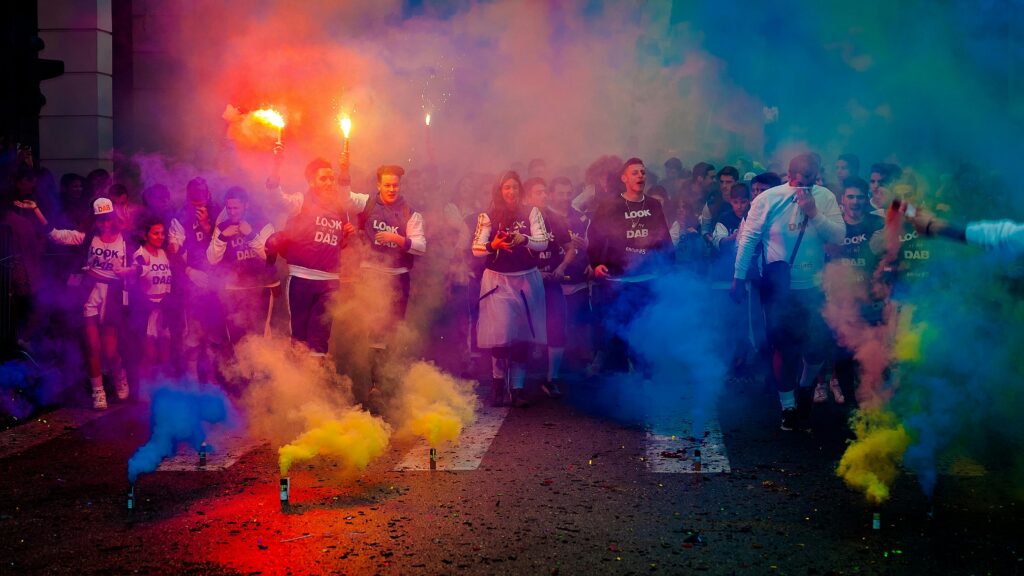 pexels-photo-889545-889545 A lively group celebrating at night with color smoke bombs in a street festival.